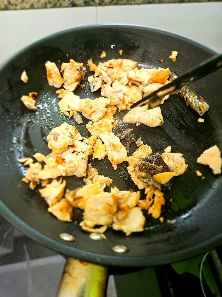 Flaking the cooked salmon. I just do it in the pan, it's fine Flaked salmon