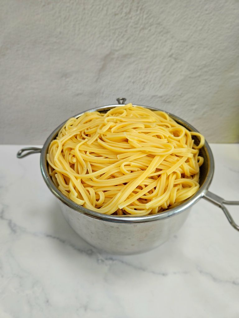 Reserving pasta water and draining Straining pasta
