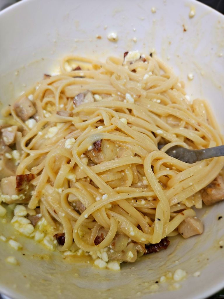 Tossing pasta and chicken with the sauce Adding pasta and chicken