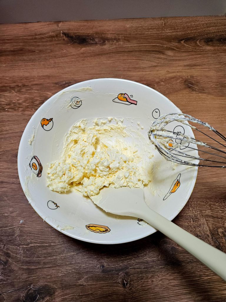 Beating softened cream cheese (and optional butter) until smooth and lump-free. Beating cream cheese and butter