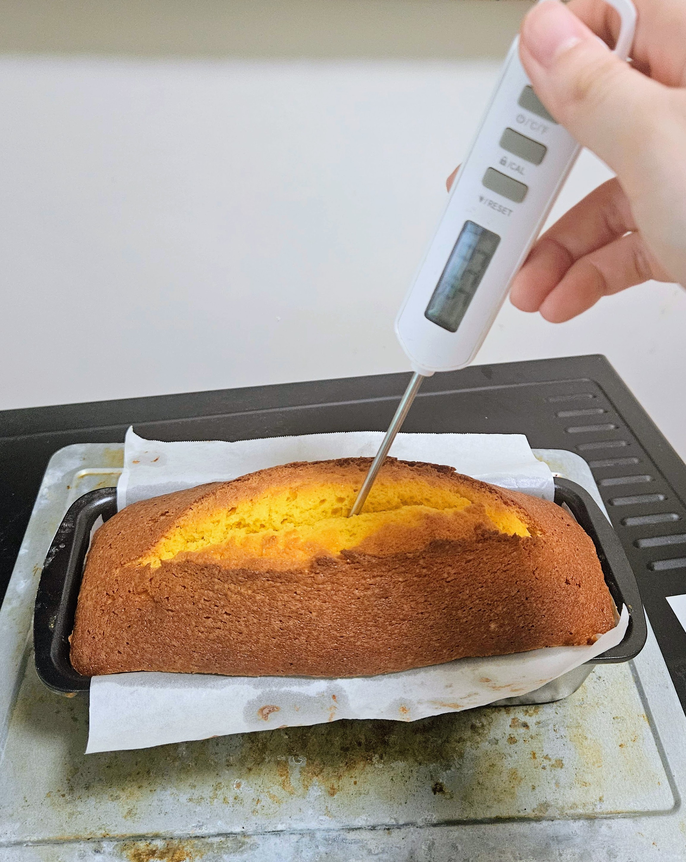 Measuring internal temperature of the cake Sticking thermometer into the cake