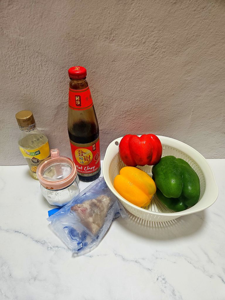Fresh ingredients for the stir fry: bell peppers, pork, oyster sauce, and seasonings
